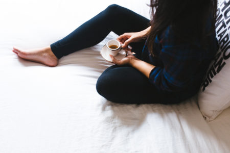 Health coach marissa vicario lists reasons why you need a health coach - girl sitting on bed with espresso